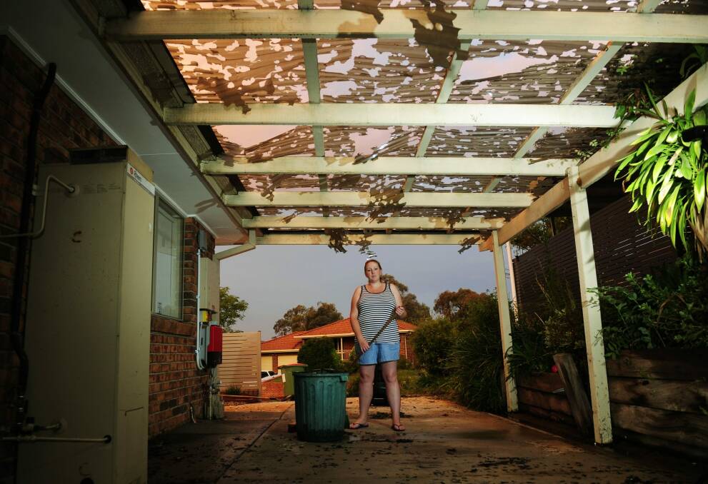 Kristel Shelley looks at the damage to her carport after a storm hits Queanbeyan. Photo: Melissa Adams 