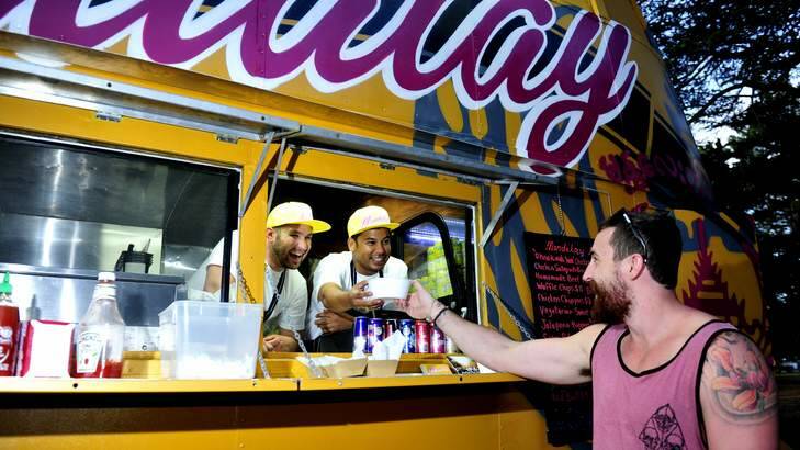 Chris Baxter enjoys a meal from Andrew Hollands and Stewart Thaung, owners of the Mandalay Bus. Photo: Melissa Adams
