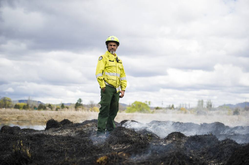 Aboriginal fire project officer Dean Freeman stands on top of burnt grassland during a cultural and ecological burn at the Jerrabomberra Wetlands. Photo: Dion Georgopoulos