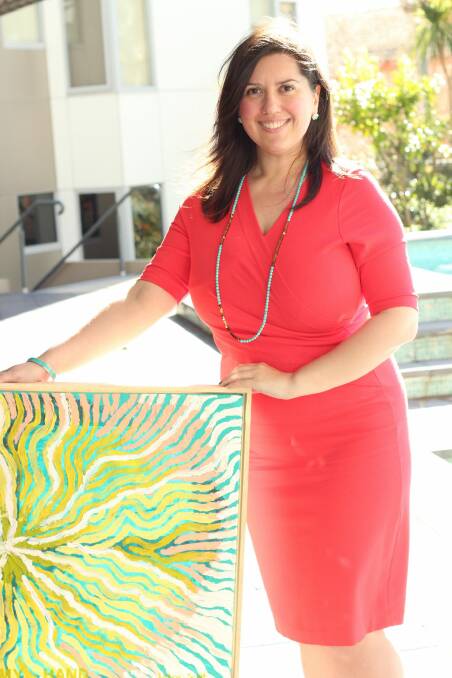 Artist Justine Scott with one of the paintings from her exhibition, Ile Mare.