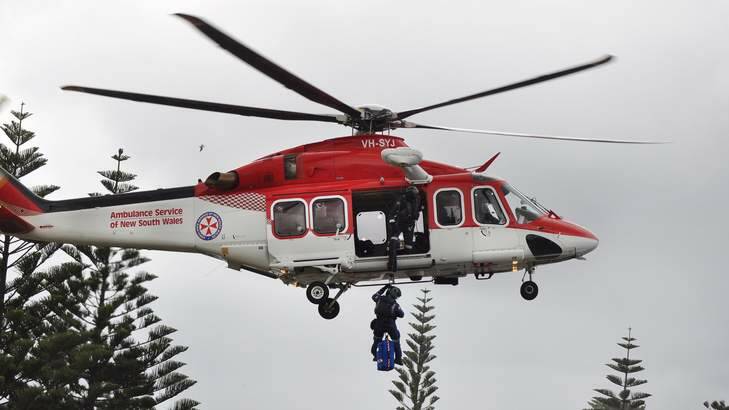 Ambulance Paramedics treat a spear fisherman who got into difficulties in the water  in Storm bay at Kiama on Tuesday, January, 2. Photo: David Hall - Kiama Independant