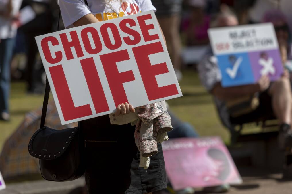 Protesters hold placards during a pro-life rally in Brisbane on September 1. Photo: AAP Image/ Glenn Hunt