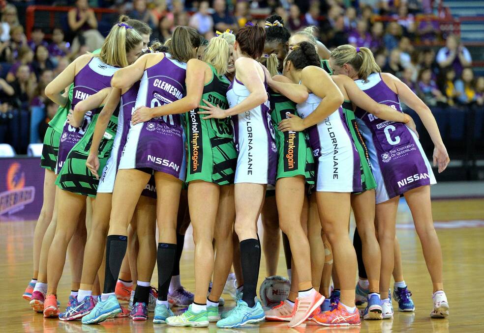 Show of unity: Players from the Firebirds and the Fever embrace before their clash at Brisbane Entertainment Centre. Photo: Getty Images
