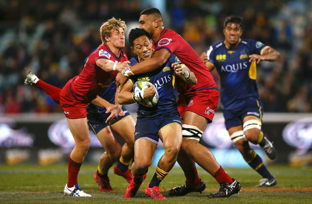 Christian Lealiifano is tackled in the Brumbies' clash against the Reds. Photo: Mark Nolan