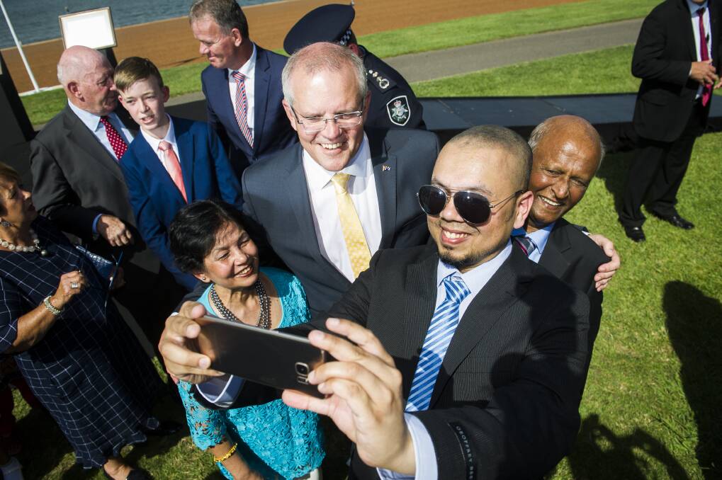 Prime Minister Scott Morrison takes a photo with new Australian citizens Farina Ahmed, Shahzad Ahmed and Iftikhar Ahmed on Saturday morning. Photo: Dion Georgopoulos