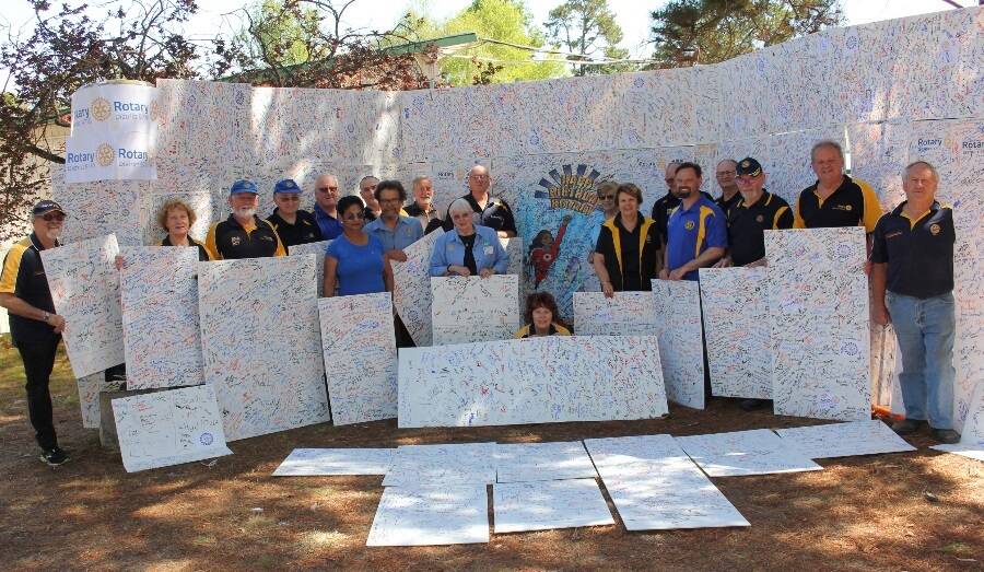 Rotary District 9710 members with the massive 90th birthday card signed by 11,515 people at its Floriade marquee. Photo: Supplied