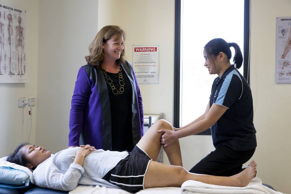 University of Canberra  professor of physiotherapy Jennie Scarvell watches her honours student Yi-Ying Zeng demonstrate one of two manual techniques  addressing knee stiffness that she is evaluating for her honours project.  The subject being demonstrated on is Mawi Than. Photo: Sitthixay Ditthavong