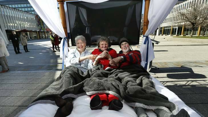 From left, Bushfire survivor Jane Smyth, Big Issue vendor Deb Bult and former Canberra Times cartoonist Geoff Pryor in bed at Civic Square for the launch of the Winter Bed Vigil to support Canberra's Homeless. Photo: Jeffrey Chan