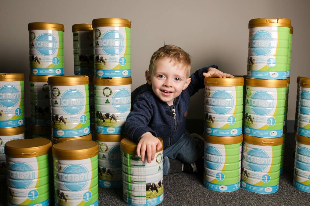 Two-year-old Jack Davey with some of the almost $200,000 worth of baby formula which will help Canberra families in need. Photo: Jamila Toderas