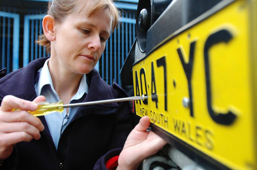 Securing number plates using tamper-proof screws Photo: Fairfax Media