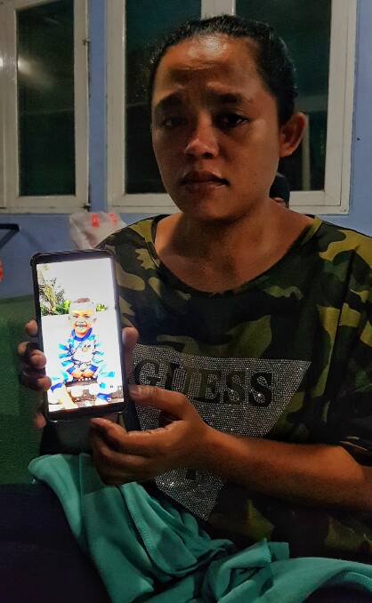 Nikita, stranded at the airport in Makassar, Sulawesi,  holds a photo of Zidan her two-year-old son, who has been missing since the earthquake.
 Photo: Amilia Rosa