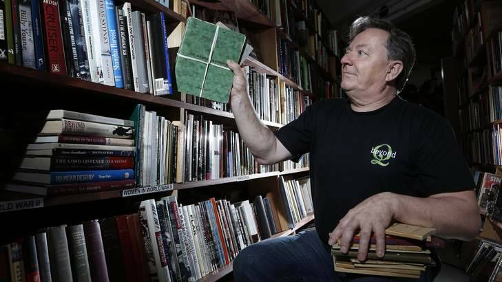 NO SURRENDER: Simon Maddox, of Beyond Q bookshop in Curtin, puts some of the training pamphlets seized by military police back on the shelves. Photo: Jeffrey Chan
