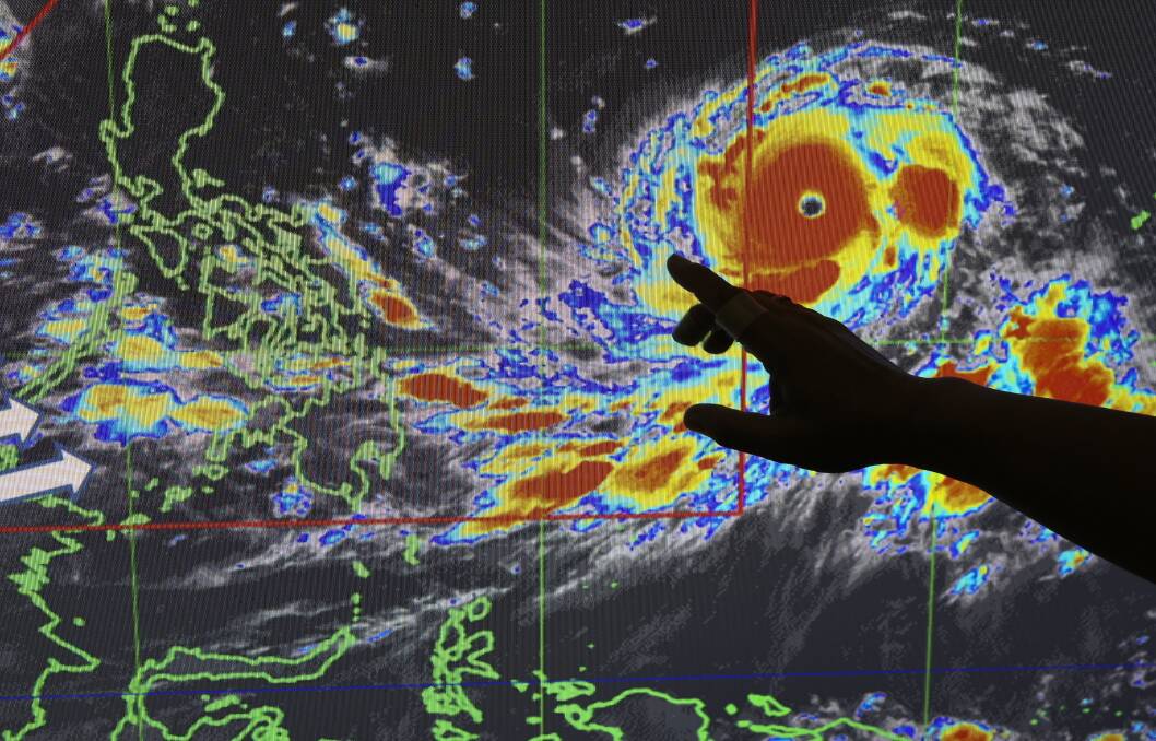 Filipino forecaster Meno Mendoza illustrates the path of typhoon Mangkhut. Photo: AP