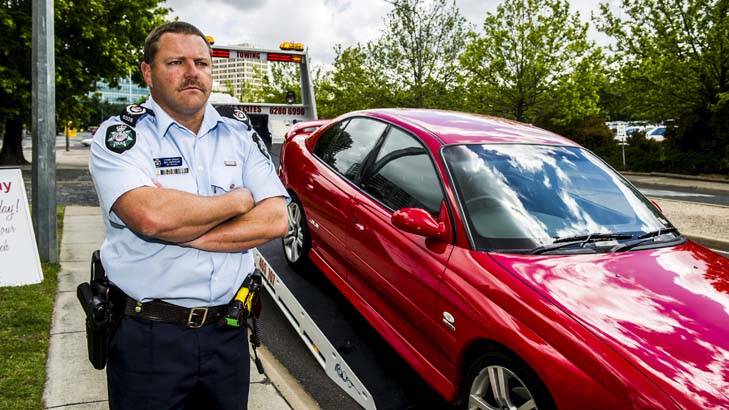 Sergeant Rod Anderson stands next to a tow truck as police warn that  they will seize vehicles from dangerous drivers at school formals. Photo: Rohan Thomson