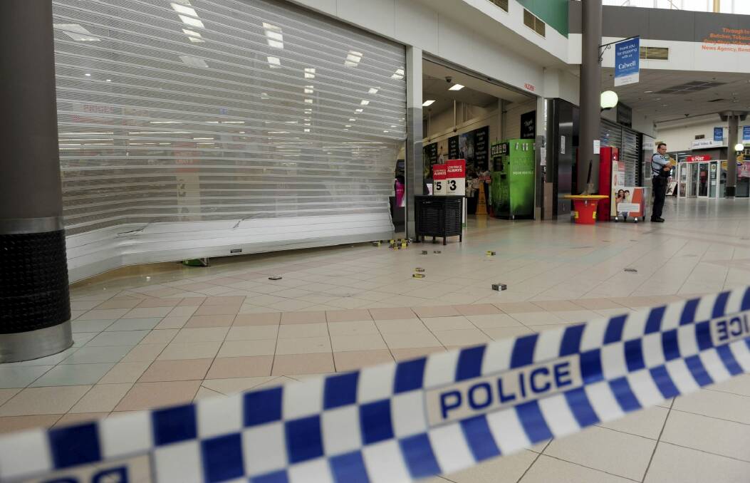 Woolworths remained closed on Friday morning after a car smashed into its roller door.  Photo: Graham Tidy