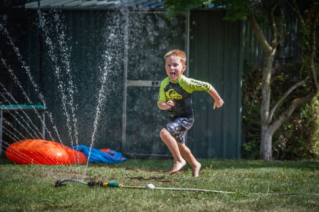 Cooper Bond, 5, of Jerrabomberra plays with water in the backyard earlier in January in a bid to cool off. Photo: Karleen Minney