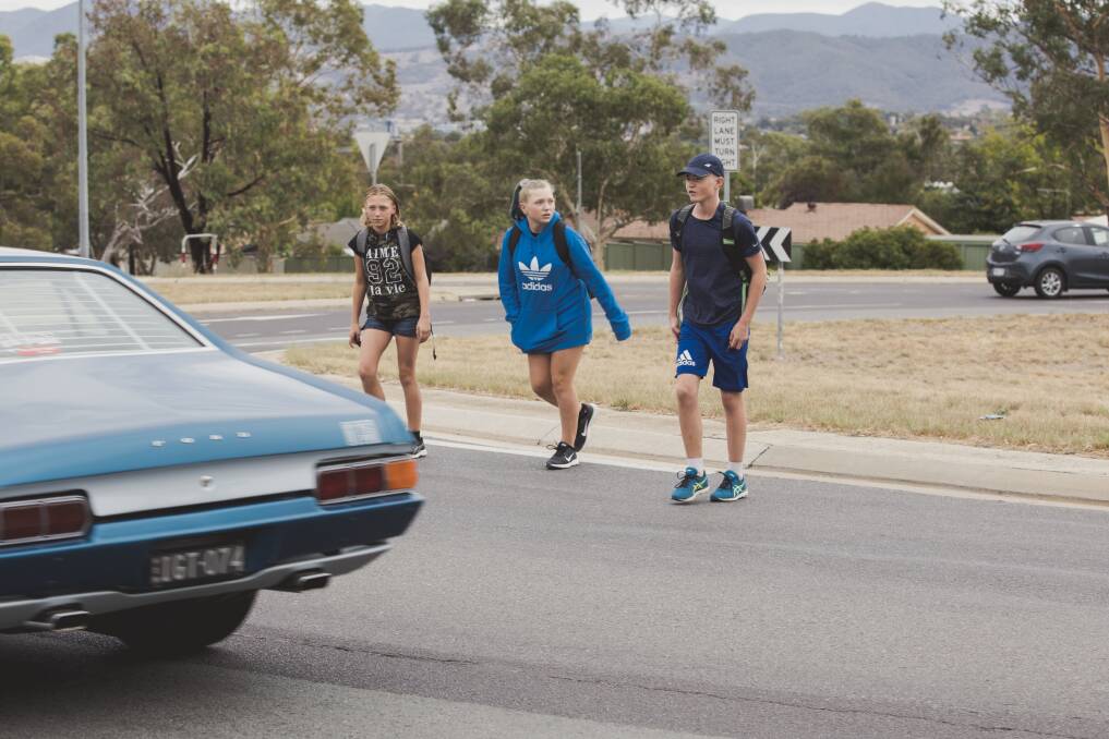 Cerys, left, Rhiannon and Harry, crossing the busy roundabout at the intersection of Erindale Drive and Sternberg Crescent. Photo: Jamila Toderas