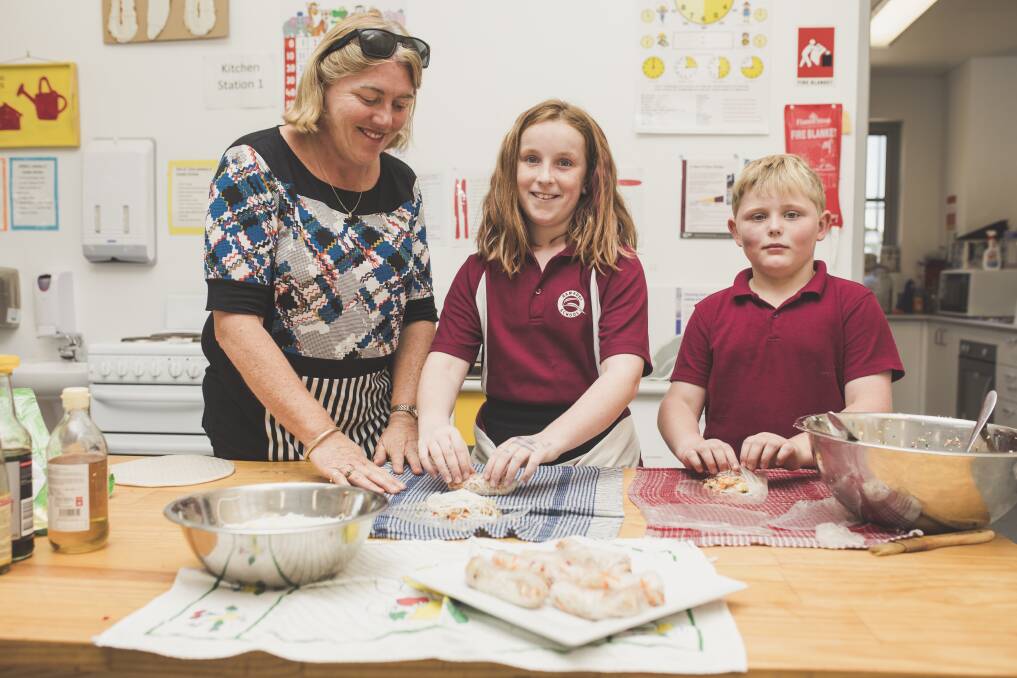 Learning support assistant Julie White, and students Scarlett Brown, 10, and Lachlan Watts, 7. Photo: Jamila Toderas