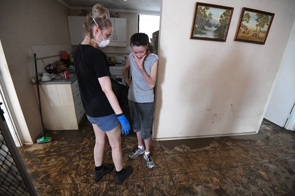 Sue Pollard (right) is comforted by her daughter inside her flood-affected house in the Townsville suburb of Hermit Park. Photo: Dan Peled - AAP