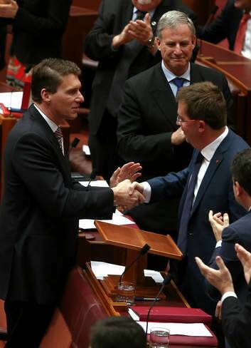 Liberal senator James McGrath is congratulated by fellow Liberal senator Cory Bernardi after delivering his first speech in the Senate. Photo: Alex Ellinghausen