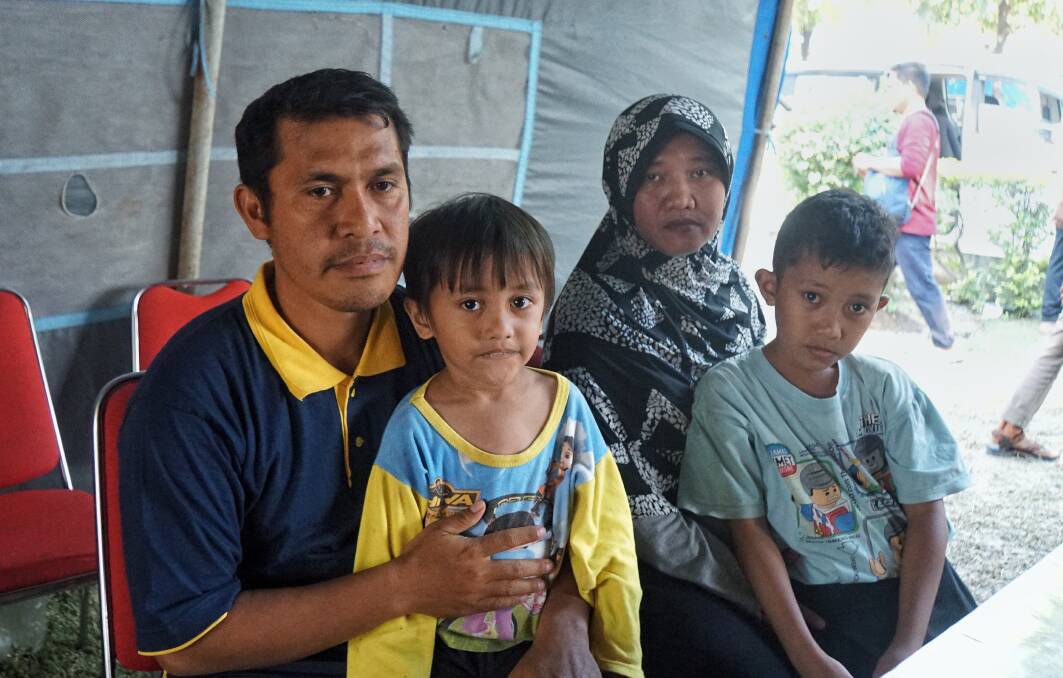 Amirudin U. Labugis (left) and his family after his house was swept away in a "tsunami of mud" following the earthquake in Sulawesi. Photo: Amilia Rosa