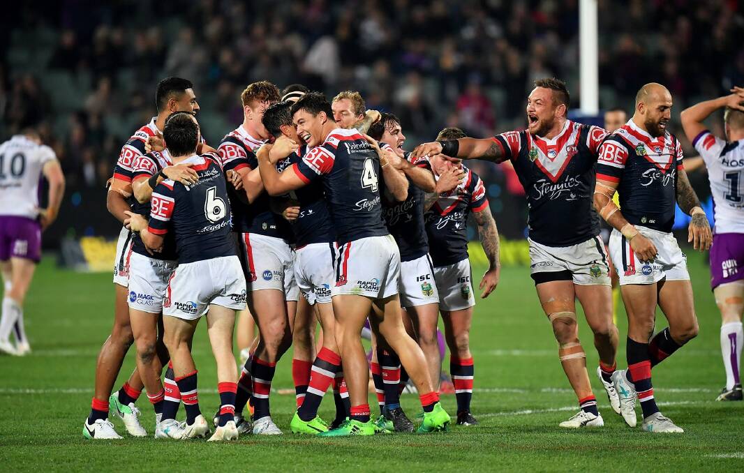 Late drama: Mitchell Pearce is mobbed by teammates after slotting home the winning field goal in golden point. Photo: Daniel Kalisz