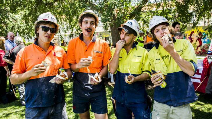 Brad Bromwich, Corey Shattos, Peter Hunt and Sheridan Godfrey enjoy their sausages at the CPSU and CFMEU organised BBQ at near the Nishi building in New Acton to raise money for Jayson Bush who was badly injured while working on the building. Photo: Rohan Thomson