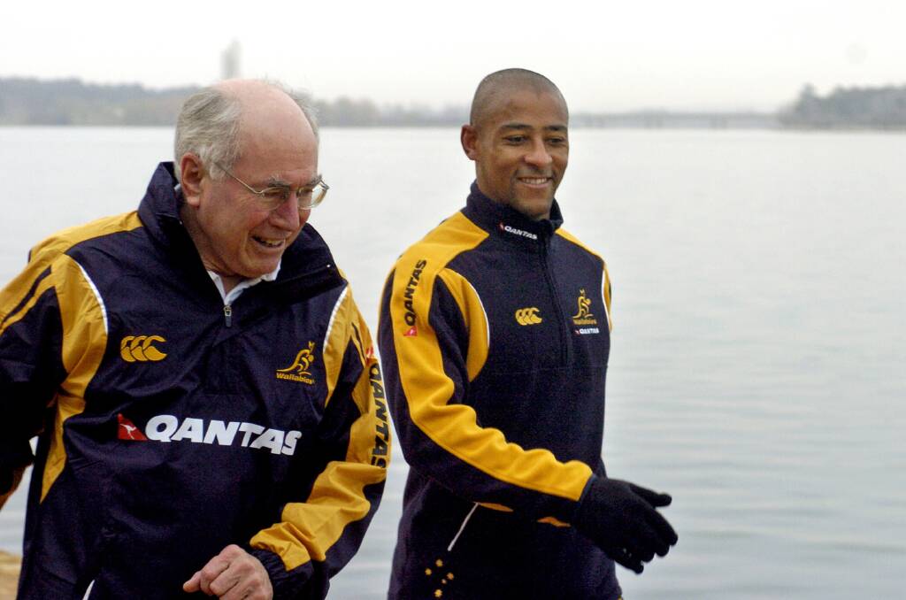 Former Wallabies captain George Gregan (right) joins then-prime minister John Howard on his early morning walk in Canberra in 2006. Photo: AAP