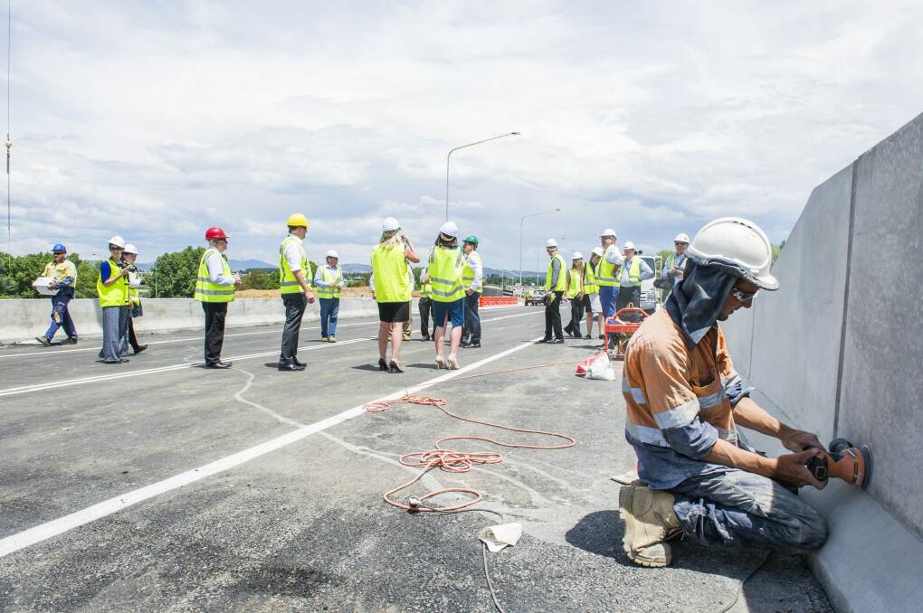 A workman puts final touches to the northbound Molonglo River bridge on the new Majura Parkway.  Photo: Rohan Thomson