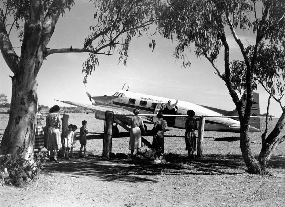 Flying Doctor being greeted by a group of waiting women and children Photo: State Library of Queensland