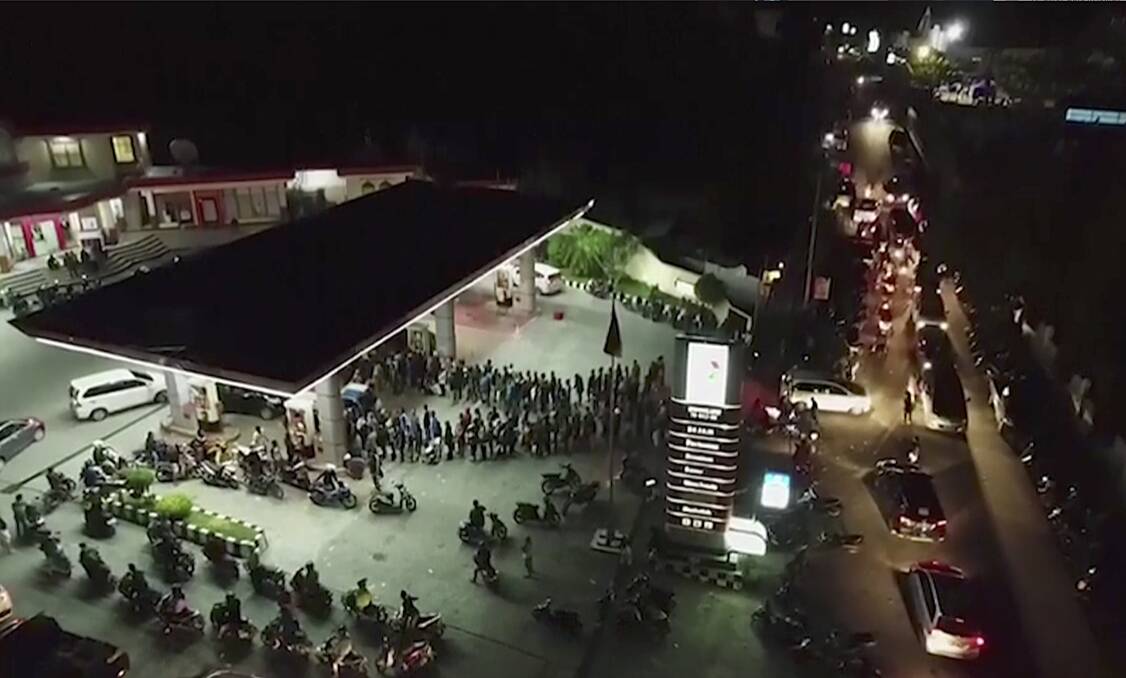 Long queues lead out from a petrol station in the earthquake and tsunami-devastated area of Palu. Photo: AP