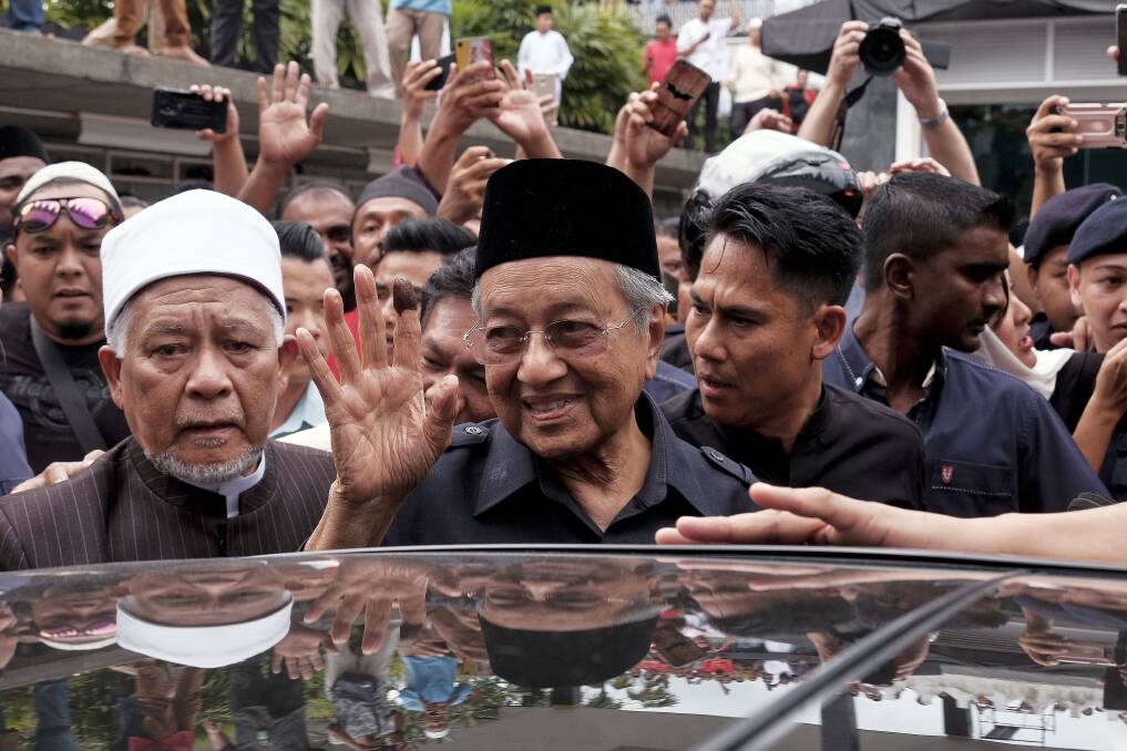 Malaysian Prime Minister Mahathir Mohamad, centre, waves to crowds leaving National Mosque after performing Friday prayers in Kuala Lumpur. Photo: AP