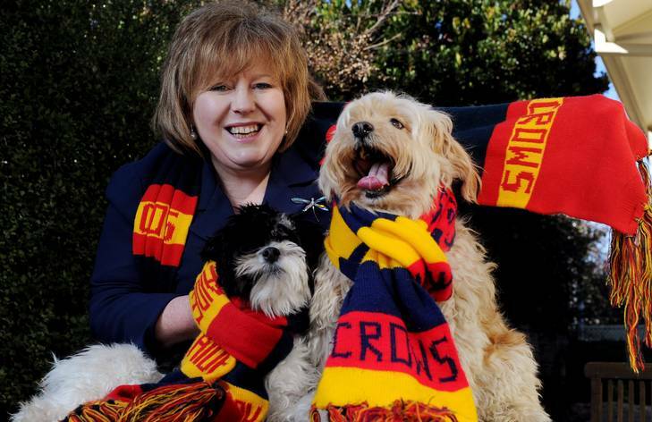Libraries ACT director Vanessa Little with her two dogs  Wally, left,  and  Harvey in there Adelaide Crows scarfs. Photo: Colleen Petch