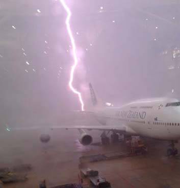 Near miss ... a lightning strike just misses a plane at Brisbane airport. Photo: Nicholas Cummins