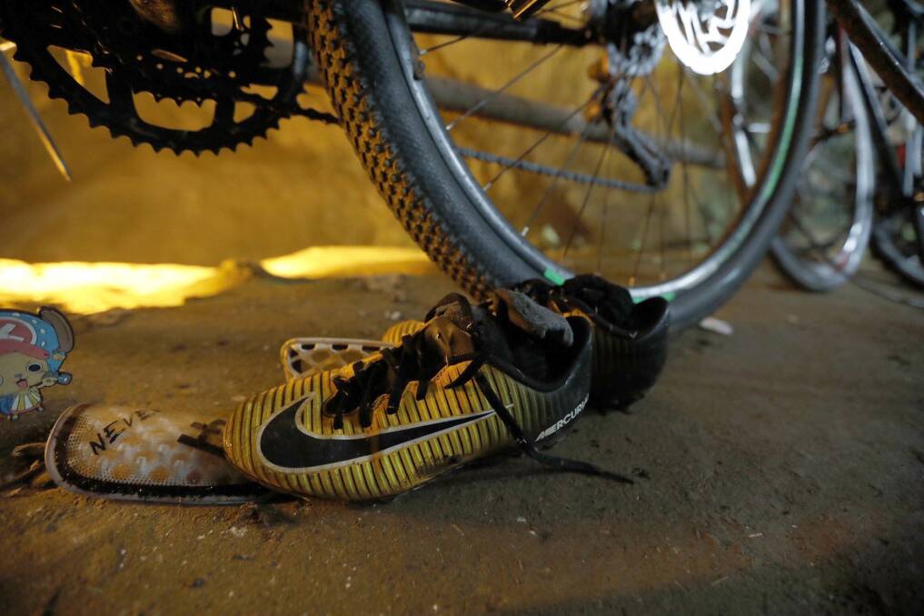 June 25, 2018: A pair of soccer boots lie next to the bicycles of the missing boys at the cave entrance in Chiang Rai, northern Thailand. Photo: AP