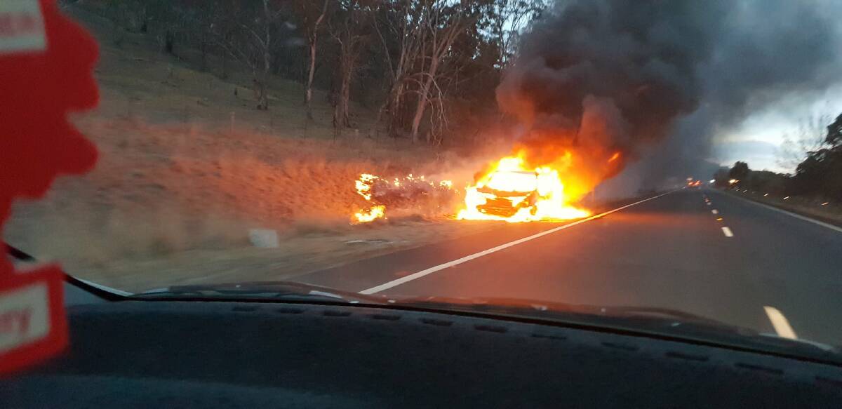 A car burns on the Monaro Highway near Michelago after hitting a kangaroo on Monday morning. Photo: Brent Wallis