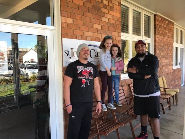Sylvie Redwin, five, and her older sister Ariella, eight, at St John's Care Reid where Sylvie handed over her $500 donation to YouthCare Canberra outreach workers Zack Bryers and Richie Unga. Photo: Supplied