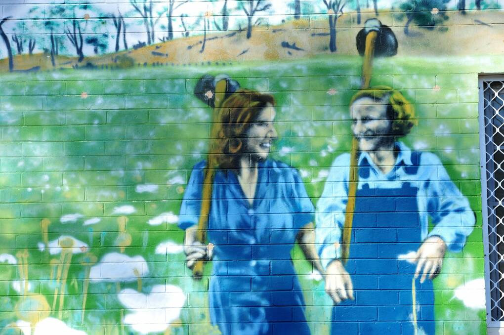 A mural by Byrd at Frencham Place in Downer. The mural is based on a famous wartime photograph of two women of the Australian Land Army going cheerfully off to work.  Photo: Melissa Adams MLA