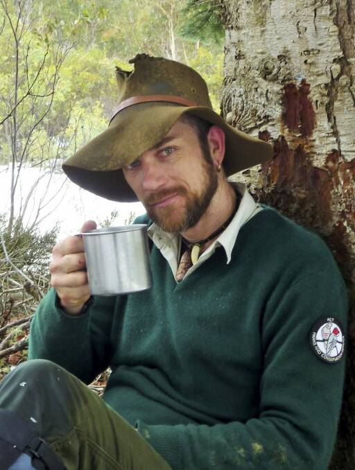 A break: ACT ranger Brandon Galpin  enjoys a cuppa under the canopy of "the sentinels".

 Photo: Tim the Yowie Man
