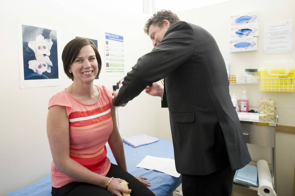 ACT Medicare Local Chair, Dr Martin Liedvogel gives Emma Kennedy a flu shot in his Fisher practice.  Photo: Jay Cronan