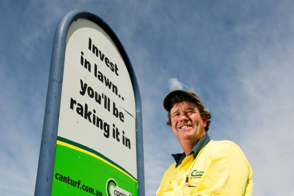 Canturf farm manager Andy Middleton with one of the business' signs which have become a much-loved contribution to the quirkiness of Canberra. Photo: Jay Cronan
