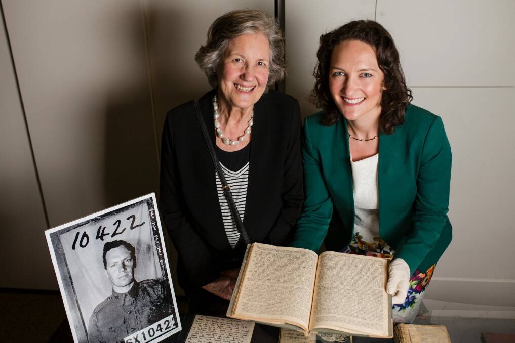Sir Alexander Downer's daughter, Stella Downer, and granddaughter Georgina Downer with the manuscript he produced during his captivity in Signapore's Changi prison camp.  Photo: Jamila Toderas
