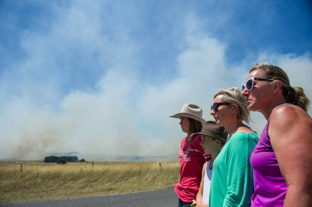 Molly, Logan and Felicity Patterson with Christa Sadler of Tarago watch on as water bombing plane flies over and are concerned for their properties. Photo: Elesa Kurtz