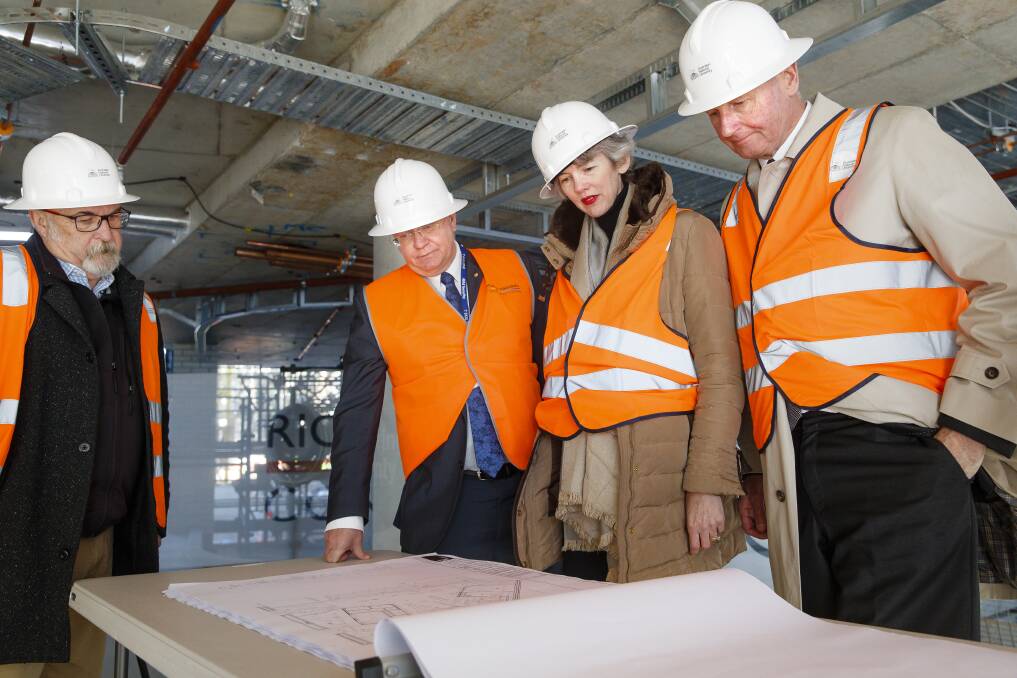 ANU vice-chancellor Brian Schmidt (centre left) and philanthropists Louise and Graham Tuckwell (right) view the plans for Wright Hall, a student residence set to open next year. Photo: Sitthixay Ditthavong