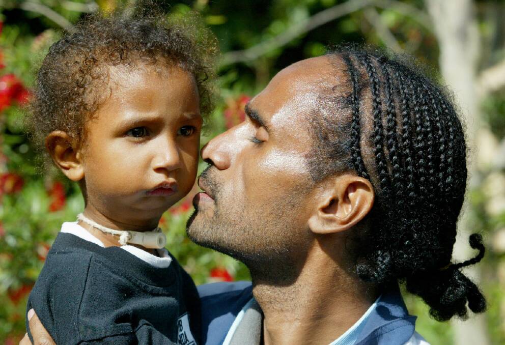  Ms Agamo as a child with her father on their first visit to Brisbane in 2003. Photo: Supplied/John Woods