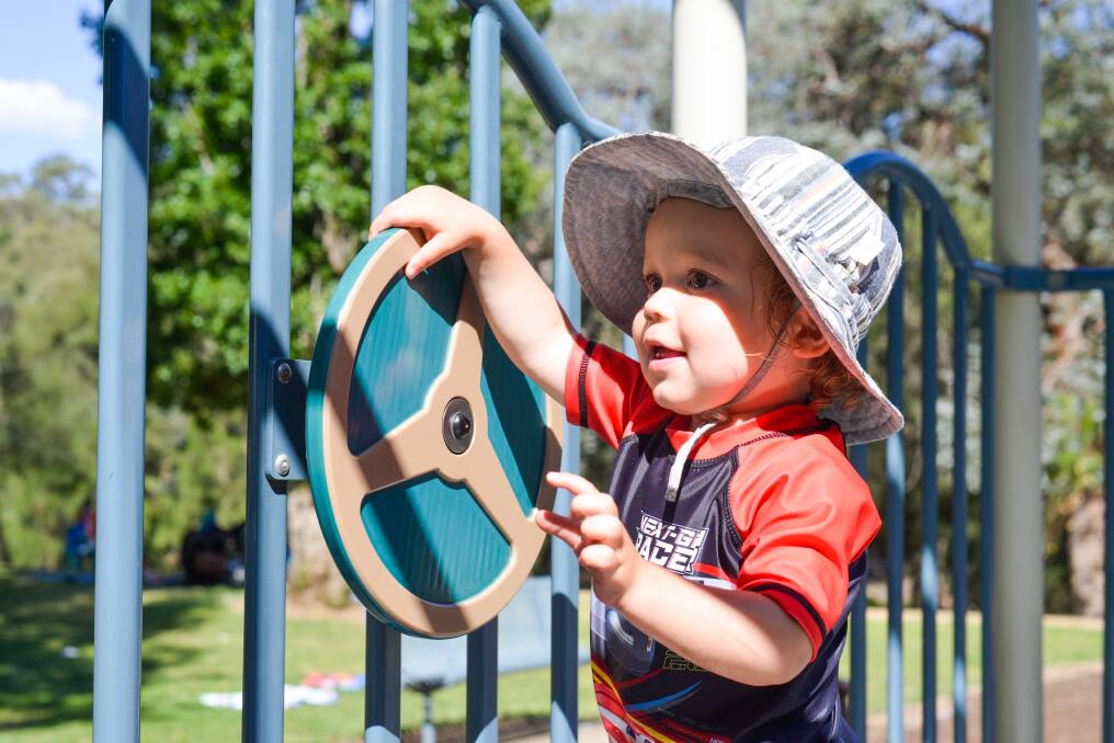 Lachlan Bush gets to grips with a steering wheel at the Cotter Avenue Playground. Photo: Tabitha Webb
