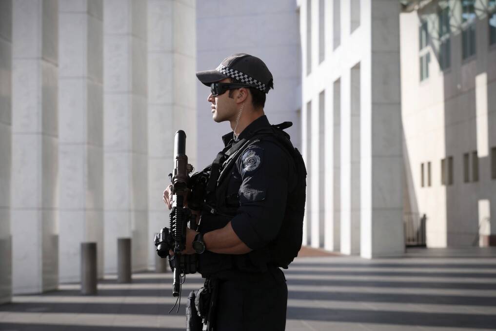 An AFP officer stands guard at the front of Parliament House in Canberra.  Photo: Andrew Meares