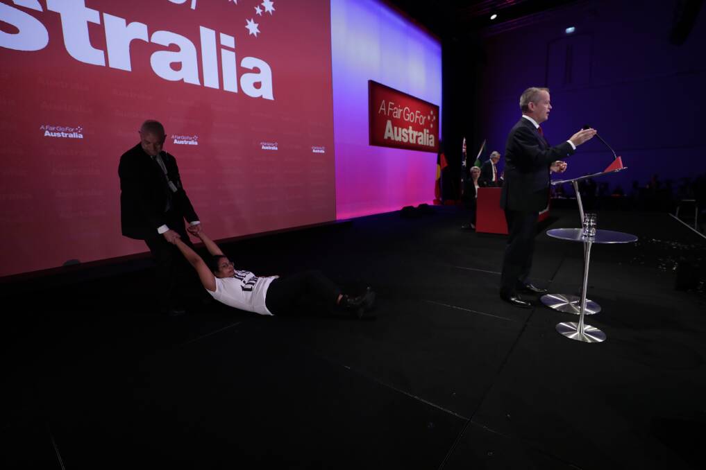 A protester is dragged off stage by security at Labor's national conference in Adelaide. Photo: Alex Ellinghausen