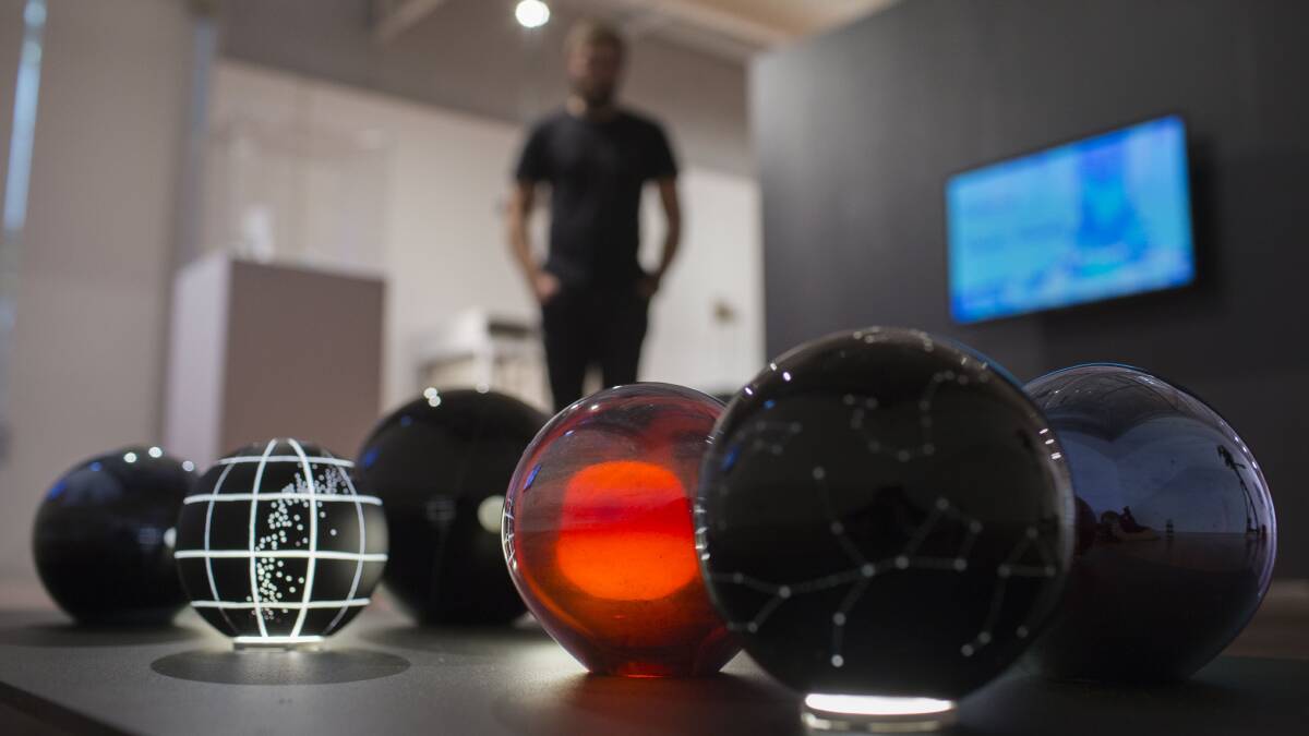 A visitor views Emeirely Nucifora-Ryan's constellation themed glass globes at the ANU School of Art and Design 2018 Graduating Exhibition.  Photo: Lannon Harley 