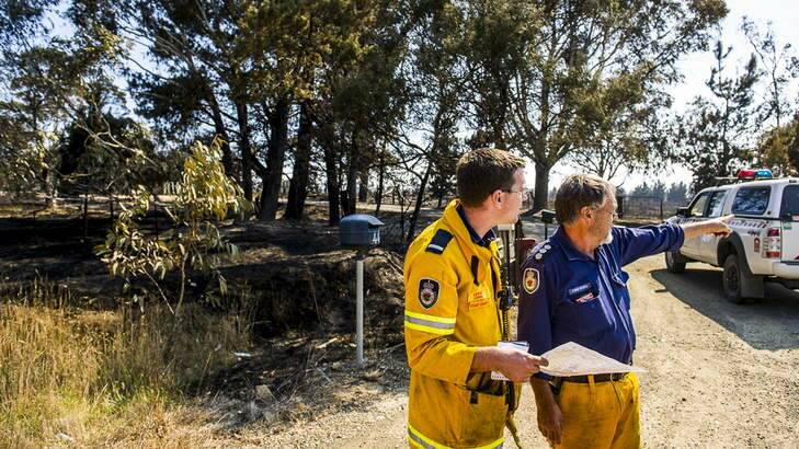 Lewis Conn and Chris Powell discuss the fires at the Kings Highway near Bungendore. Photo: Rohan Thomson